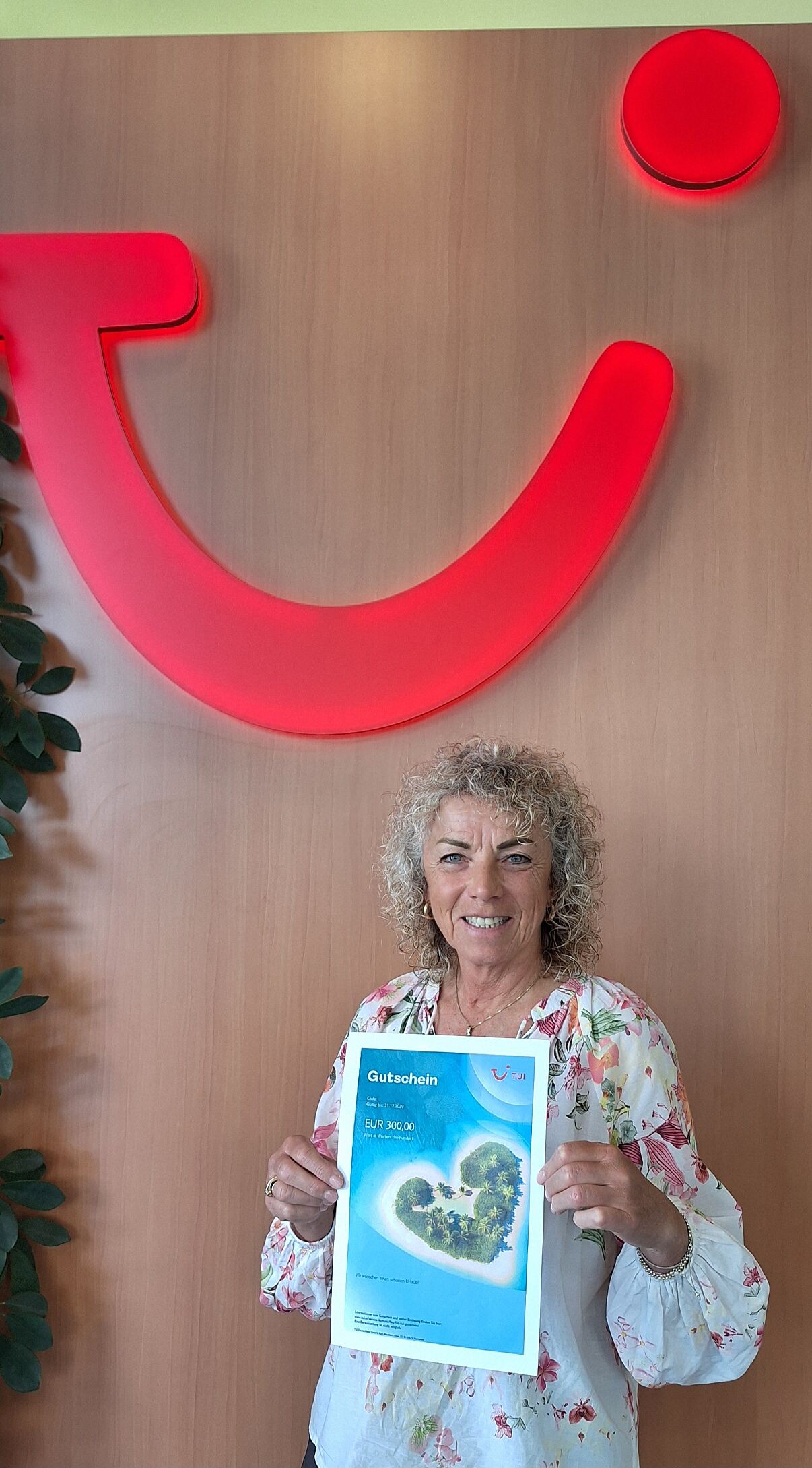 Judith Moser von TUI Das Reisebüro freut sich über einen TUI Gutschein im Wert von 300 Euro